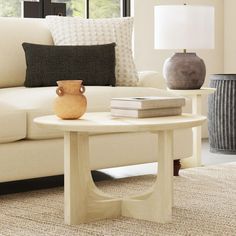 a living room with a couch, table and lamp in it's centerpiece