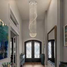 an elegant entry way with chandelier and large mirror on the wall above it