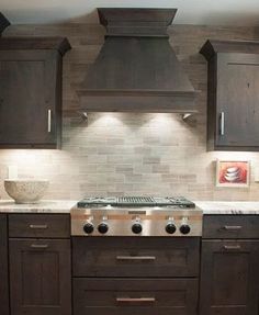 a stove top oven sitting inside of a kitchen next to wooden cabinets and counter tops