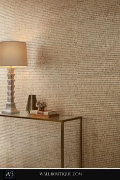 a table with a lamp on it next to a wall