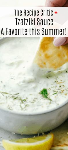 a person dipping sauce into a bowl with lemon wedges on the side and text overlay that reads, the recipe critic tazi sauce a favorite this summer