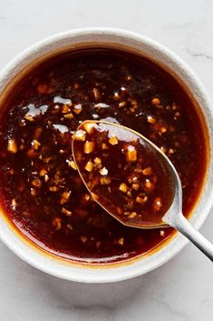 a bowl of chili sauce with a spoon in it