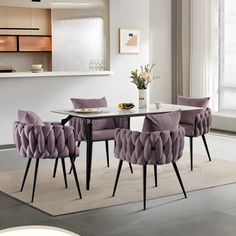 a dining room table with purple chairs around it