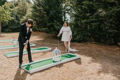 a man and woman playing miniature golf in the sand at their backyard wedding reception venue