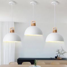 three lights hanging over a dining room table