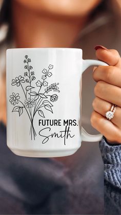 a woman holding a white coffee mug with the words future mrs smith printed on it