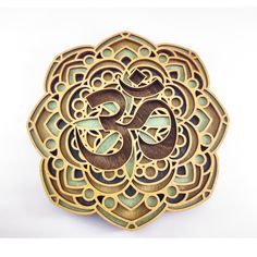 an intricately designed wooden brooch with the word om shan shan shan shan shan shan shan