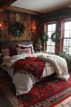 a bedroom decorated for christmas with red and white bedding, wreaths and lights