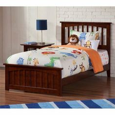 a child's bed with an animal themed comforter and pillow on top of it