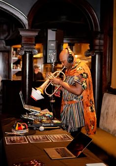 a man in headphones playing a trumpet at a table with other items on it