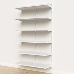 an empty white shelf in the corner of a room