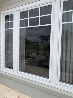 an image of a house with the reflection of it in the glass door and windows