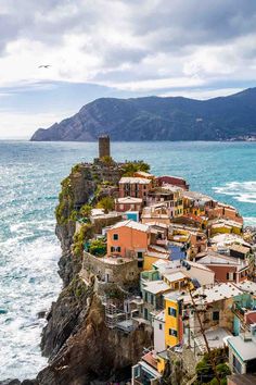 an aerial view of houses on the edge of a cliff by the ocean