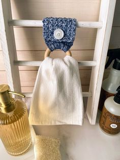 a white towel sitting on top of a wooden shelf next to a bottle and soap dispenser