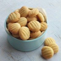 a blue bowl filled with cookies on top of a white countertop next to two small ones