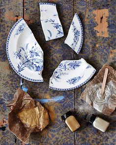 an assortment of blue and white dishes on top of a wooden table with brown paper