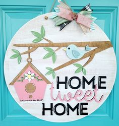 a wooden sign that says home sweet home with two birds on a branch and a birdhouse