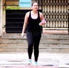 a woman is walking down the street with an object in her hand