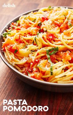 pasta with tomato sauce and parmesan cheese in a pan on a wooden table