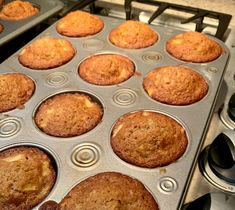 several muffins in a pan on top of an oven burner with other muffins