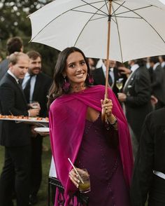 a woman in a purple dress holding an umbrella