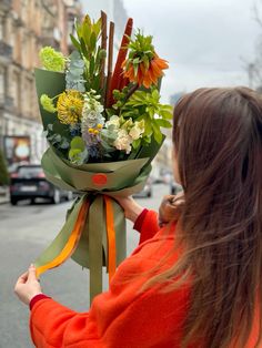 a woman holding a bouquet of flowers on the street