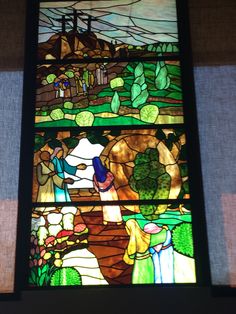 a stained glass window with people and animals on it's sides in a church