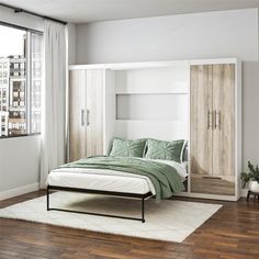 a bedroom with a bed, closets and a window overlooking the cityscape