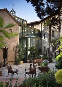 two chairs sitting in front of a building with glass doors on it's sides