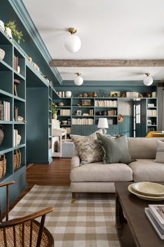 a living room filled with furniture and bookshelves covered in lots of bookcases