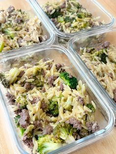 four plastic containers filled with food sitting on top of a wooden table next to broccoli