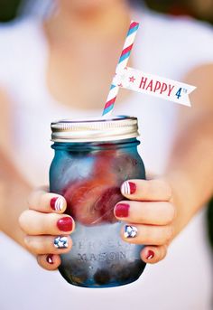 a woman holding a mason jar with a happy 4 on it and a striped straw