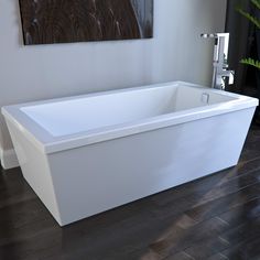 a white bath tub sitting on top of a wooden floor next to a painting above it