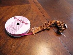 a spool of yarn is on the floor next to a reel of string that has been cut off