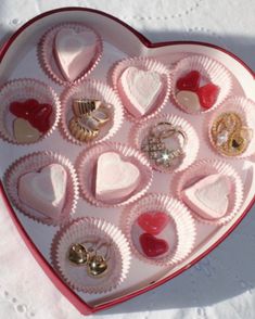 a heart shaped box filled with lots of different types of jewelry on top of a table