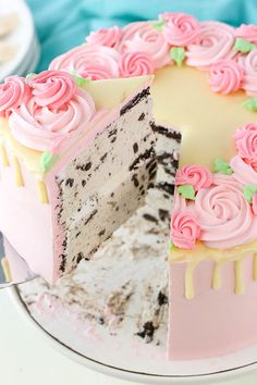 a cake with pink frosting and roses on it is cut into pieces to show the inside