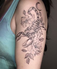 a woman's arm with flowers and a scorpion tattoo on the left side of her arm