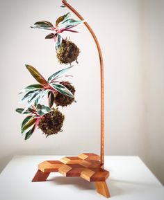 a wooden sculpture with flowers on it and a plant growing out of the top one