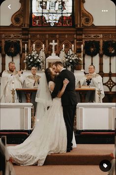 a bride and groom kissing in front of the alter