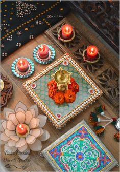 an assortment of decorative items displayed on a wooden surface with candles and flowers in the center