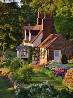 the house is surrounded by beautiful flowers and trees