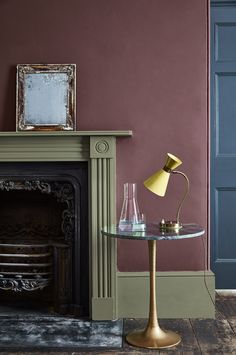 a living room with a fire place and a lamp on the table next to it