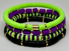 three different colored bracelets with gold accents on each one and purple, green, and black beads