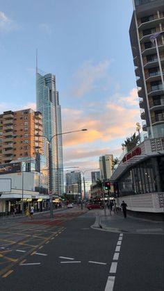 an empty city street with tall buildings in the background