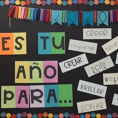 the bulletin board is decorated with colorful papers and letters that spell out words, which are written in spanish