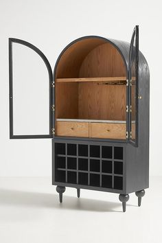 a black cabinet with an arched door and wine rack in the middle, on wheels