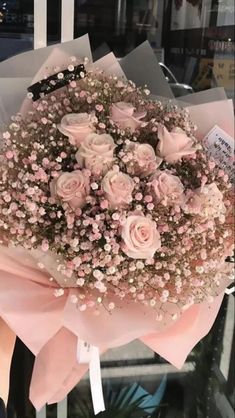 a bouquet of pink roses in front of a window