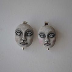 two masks are hanging on the wall next to each other, with eyes painted on them