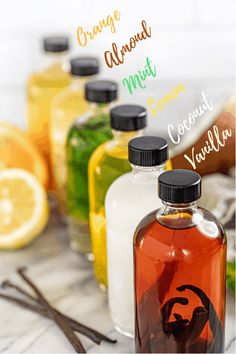 several bottles filled with liquid sitting on top of a table next to sliced lemons