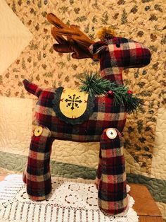 a plaid horse is standing on a doily with pine needles in it's mouth